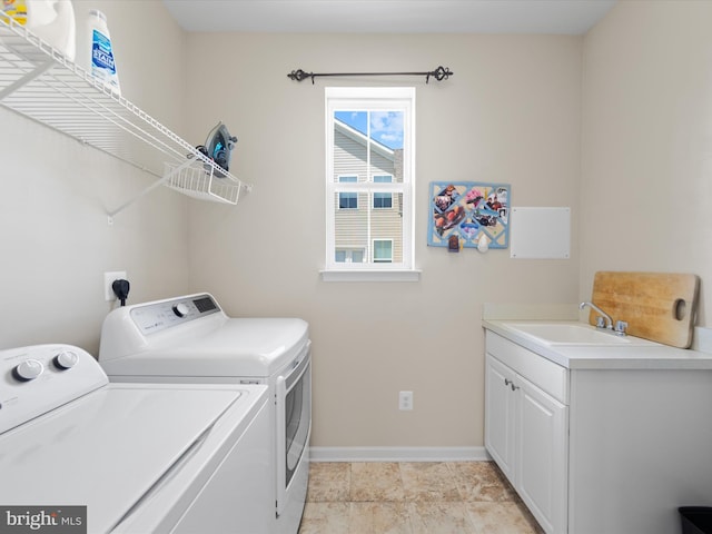 laundry room featuring cabinets, sink, and washing machine and clothes dryer