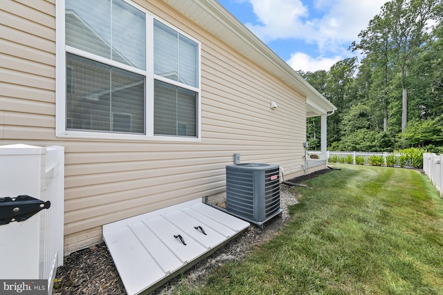 view of side of property featuring central AC and a lawn