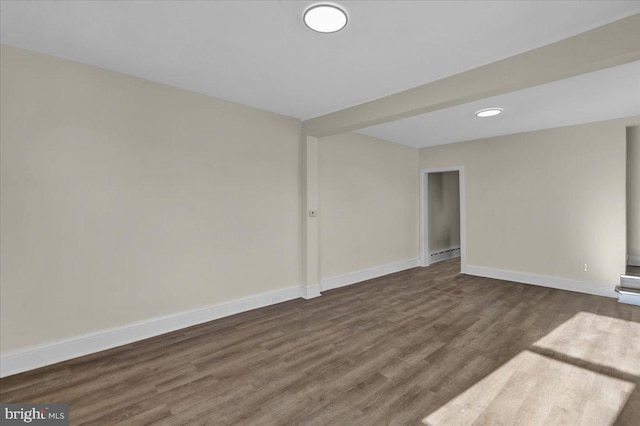 spare room featuring dark hardwood / wood-style flooring and baseboard heating