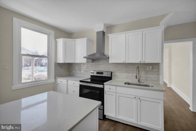 kitchen featuring stainless steel electric stove, wall chimney exhaust hood, white cabinetry, and sink