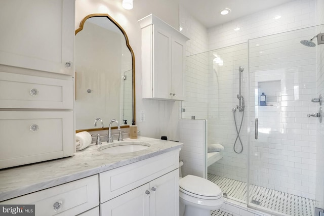 bathroom featuring tile patterned floors, toilet, vanity, and walk in shower