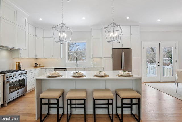 kitchen with high quality appliances, white cabinets, and a center island