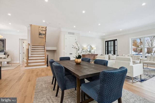 dining area featuring ornamental molding and light hardwood / wood-style floors