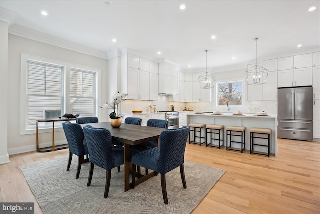 dining area featuring light hardwood / wood-style floors and crown molding