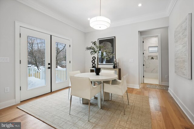 dining room with light hardwood / wood-style flooring, french doors, and crown molding