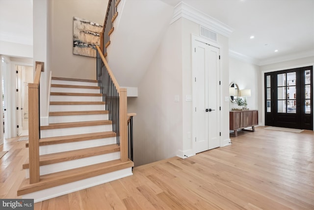 entryway with light hardwood / wood-style floors and ornamental molding