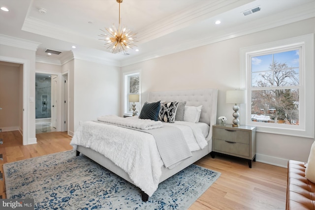 bedroom with ensuite bathroom, an inviting chandelier, light wood-type flooring, and crown molding