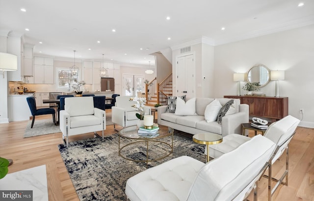 living room featuring light hardwood / wood-style floors and crown molding