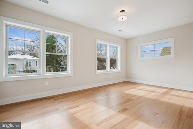 spare room featuring light hardwood / wood-style floors and plenty of natural light