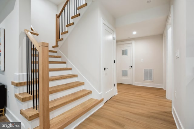 stairs with hardwood / wood-style floors