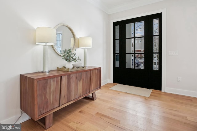 foyer entrance with light wood-type flooring and crown molding