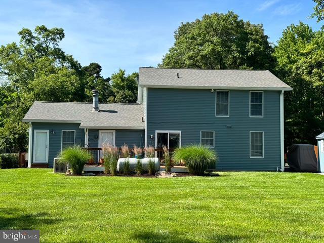 rear view of house featuring a yard