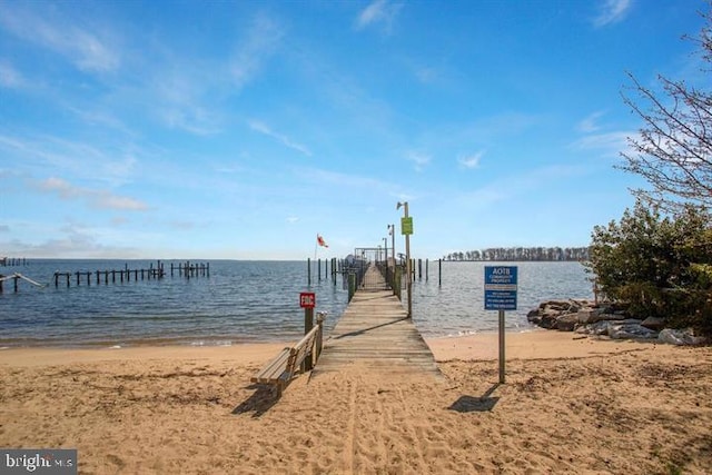 view of dock with a water view and a view of the beach