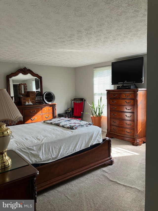 carpeted bedroom featuring a textured ceiling