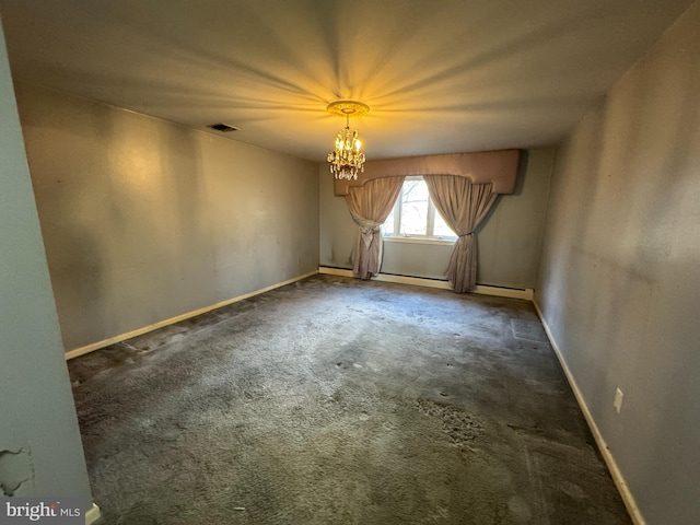 carpeted spare room featuring a notable chandelier