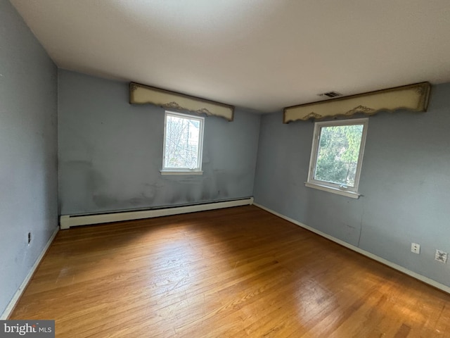 spare room featuring light wood-type flooring and a baseboard radiator