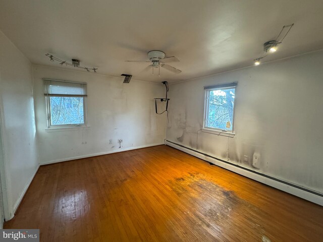 unfurnished room featuring ceiling fan, wood-type flooring, and a baseboard radiator