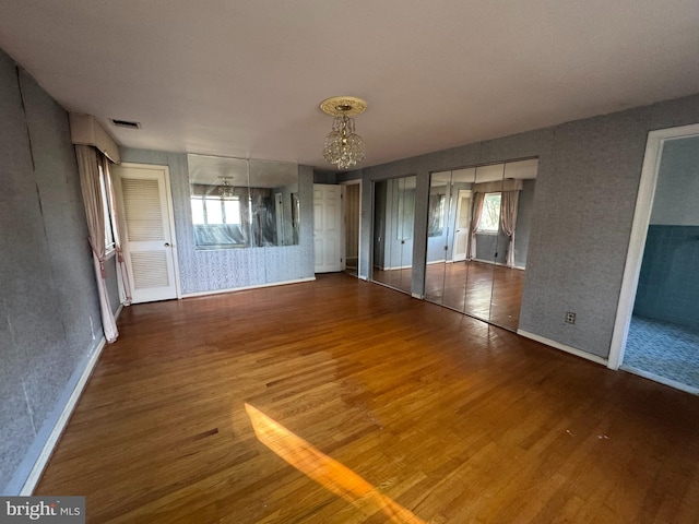 unfurnished room featuring a chandelier and hardwood / wood-style floors