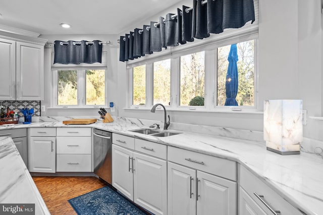 kitchen with white cabinets, a wealth of natural light, sink, light hardwood / wood-style flooring, and dishwasher