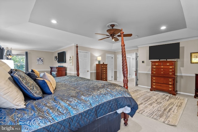 carpeted bedroom with ceiling fan, a raised ceiling, and ornamental molding