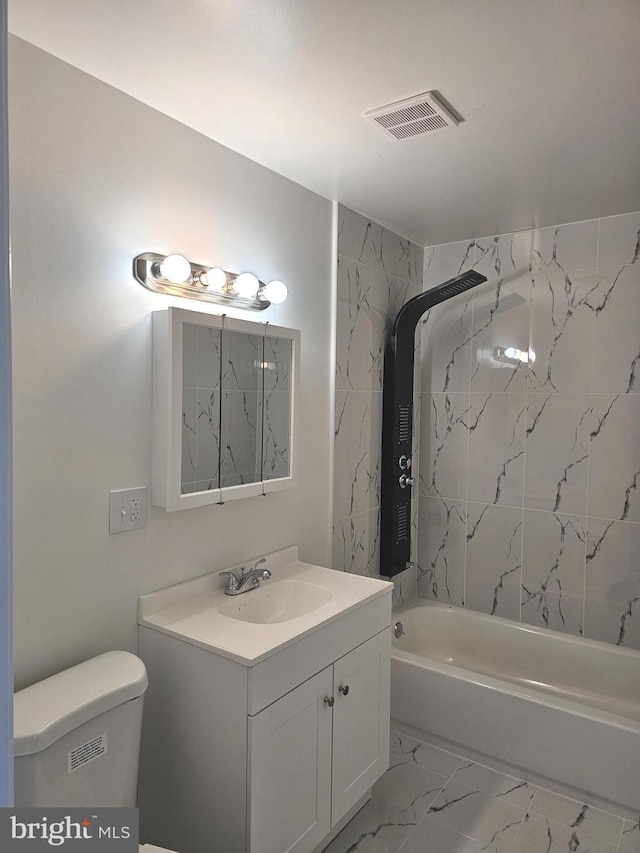 full bathroom with vanity, toilet, and tiled shower / bath