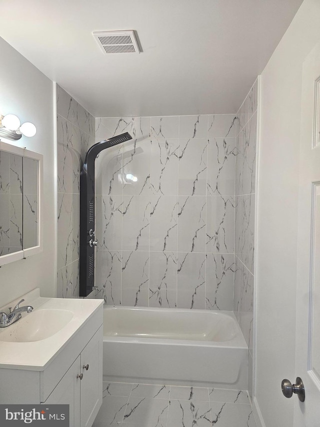 bathroom featuring vanity and tiled shower / bath