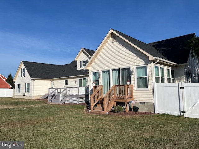 rear view of house with a yard and a wooden deck