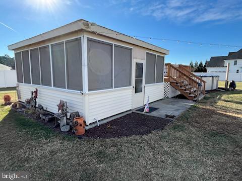 view of property exterior featuring a sunroom and a yard