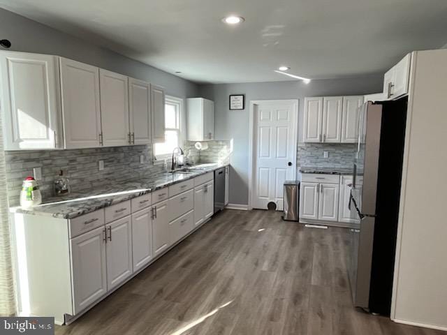 kitchen with white cabinetry, stainless steel appliances, and wood-type flooring