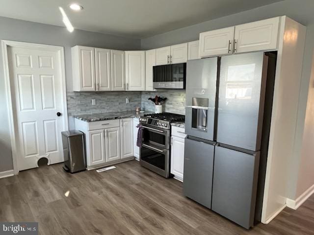 kitchen with decorative backsplash, appliances with stainless steel finishes, dark hardwood / wood-style floors, and white cabinetry