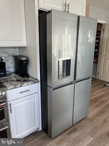 kitchen featuring white cabinetry, backsplash, stainless steel fridge with ice dispenser, and light hardwood / wood-style flooring