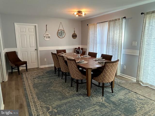 dining space with plenty of natural light and dark hardwood / wood-style floors