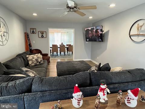 living room featuring ceiling fan and hardwood / wood-style flooring