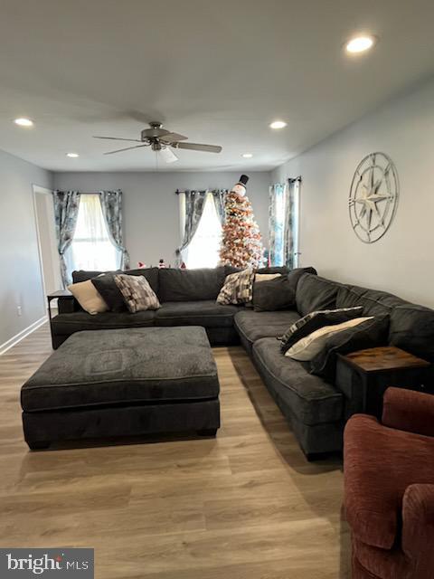 living room featuring ceiling fan and light hardwood / wood-style floors