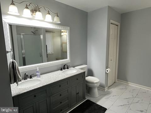 bathroom with vanity, an enclosed shower, and toilet