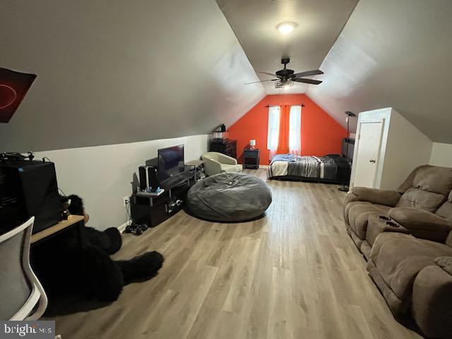 interior space with ceiling fan, wood-type flooring, and lofted ceiling