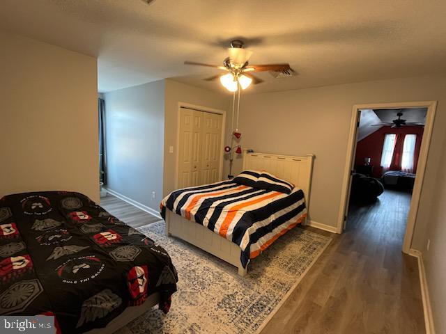 bedroom featuring ceiling fan, a closet, and dark hardwood / wood-style floors