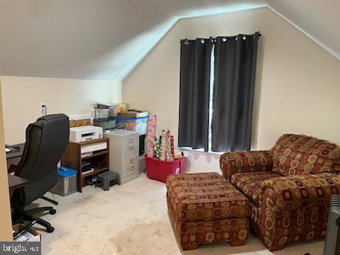 home office featuring light colored carpet and vaulted ceiling