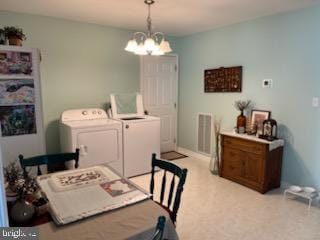 carpeted dining space featuring washing machine and dryer and a notable chandelier