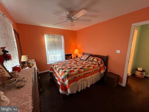 bedroom with dark colored carpet and ceiling fan