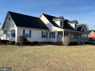 view of side of home with a porch and a lawn