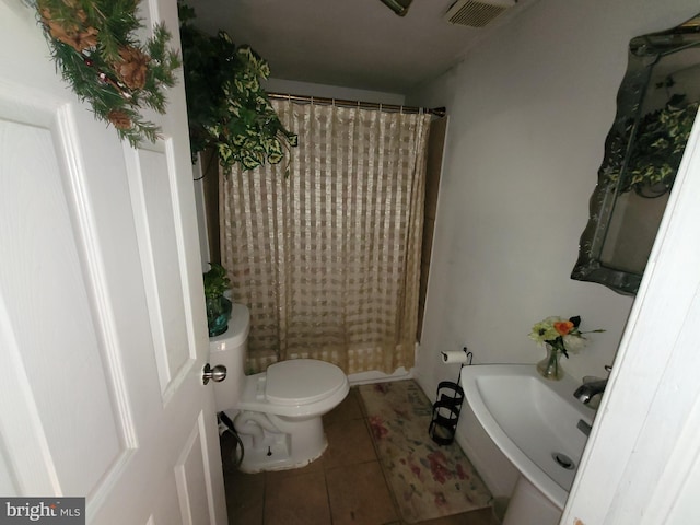 bathroom featuring tile patterned floors, toilet, and walk in shower