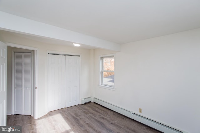 unfurnished bedroom with a baseboard radiator and light hardwood / wood-style floors