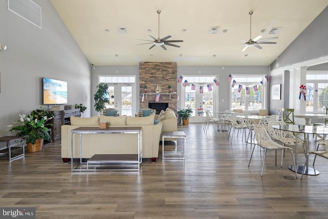 living room featuring high vaulted ceiling, dark hardwood / wood-style flooring, a wealth of natural light, and french doors