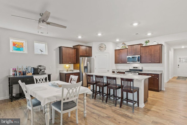 dining area with ceiling fan and light hardwood / wood-style flooring