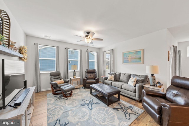 living room featuring ceiling fan and light hardwood / wood-style flooring