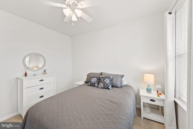 bedroom with ceiling fan, light colored carpet, and multiple windows