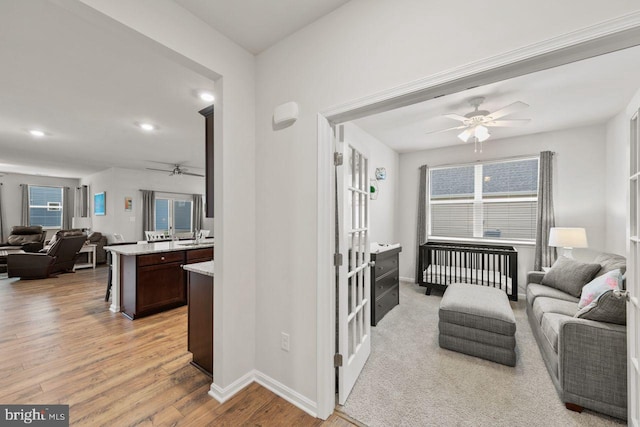 living room featuring light wood-type flooring, a wealth of natural light, and ceiling fan