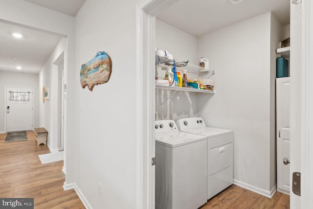 washroom with light hardwood / wood-style floors and washing machine and clothes dryer