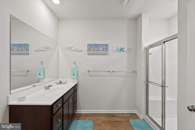 bathroom with vanity, wood-type flooring, and a shower with door